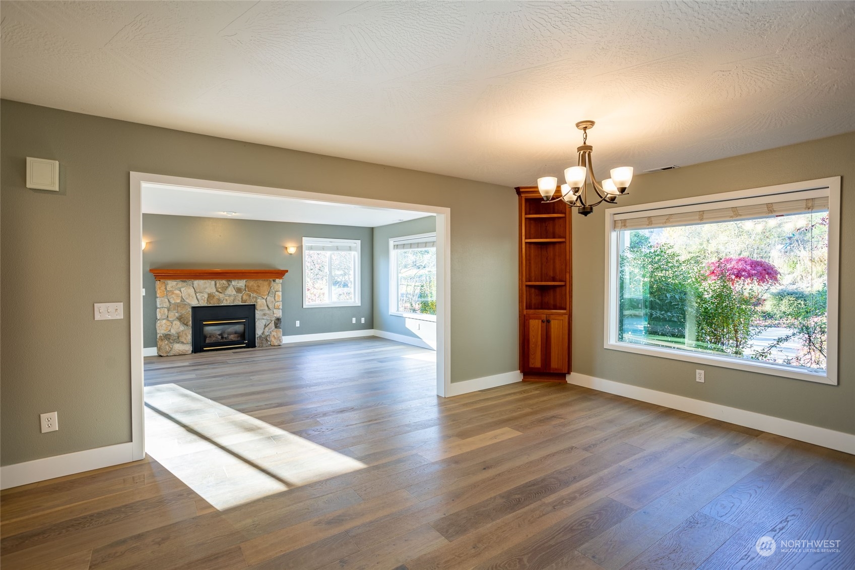 150 Logan Hill Road Chehalis, WA 98532 - Photo 6 of 40 an empty room with wooden floor fireplace and chandelier