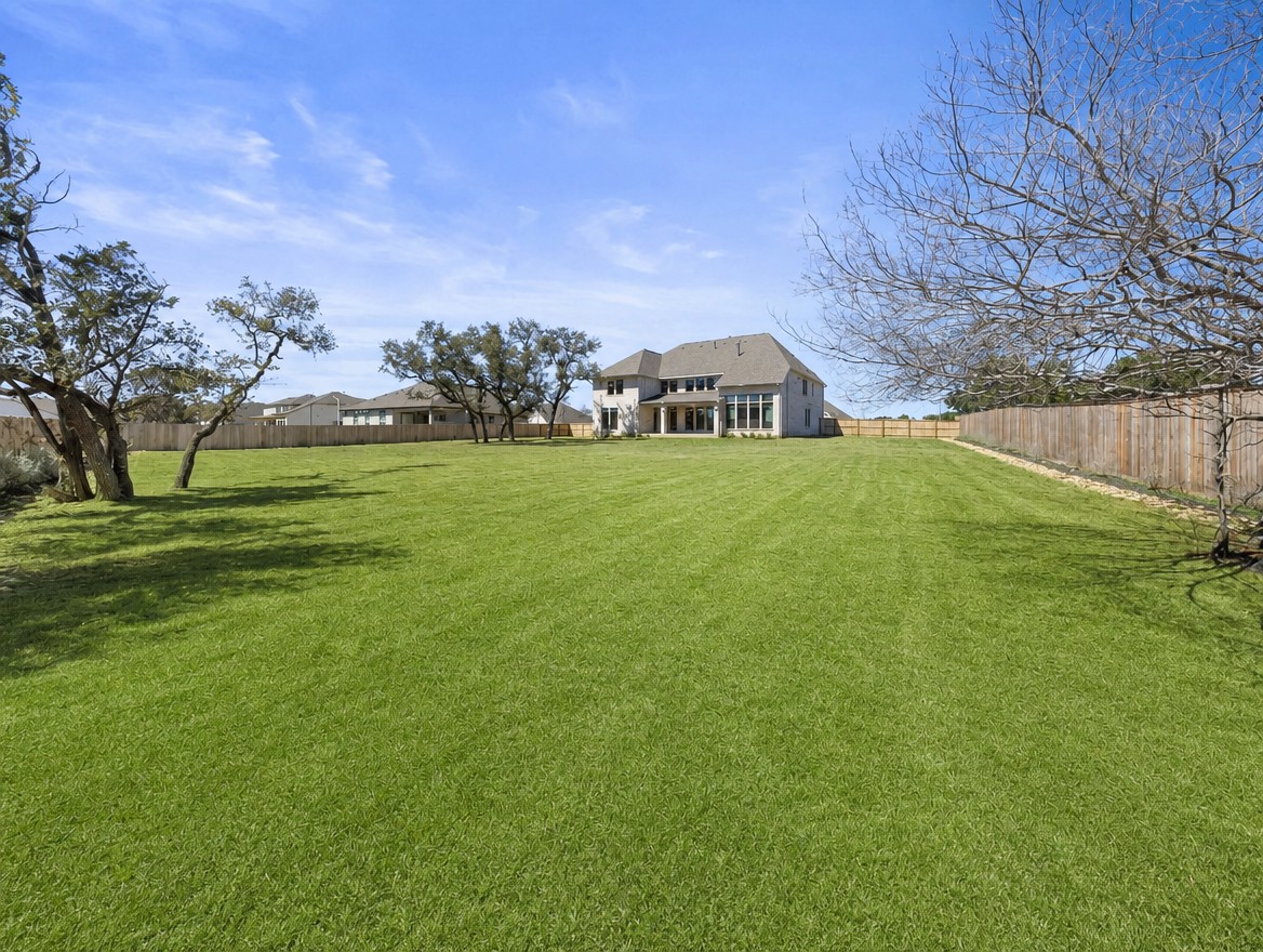 1440 Riva Ridge Drive Leander, TX 78641 - Photo 29 of 37 An expansive green lawn provides ample space for outdoor activities, leading to a generously proportioned residence.
