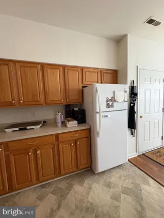 a kitchen with stainless steel appliances granite countertop a refrigerator a stove a sink and white cabinets