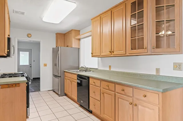 a kitchen with stainless steel appliances granite countertop a stove a refrigerator and a sink