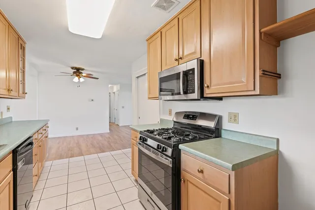 a kitchen with granite countertop a stove a sink and a microwave