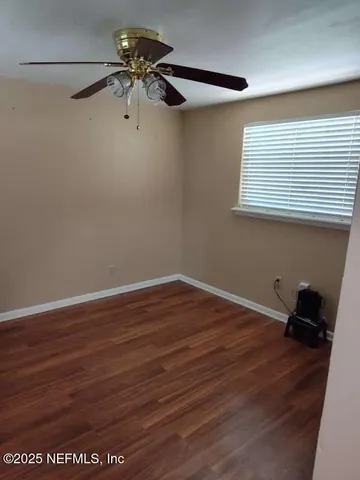 a view of a room with wooden floor and a window