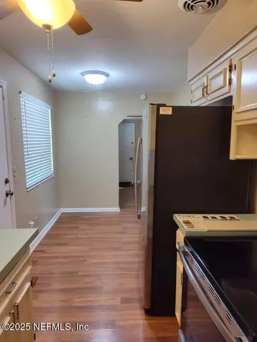 a view of an empty room with a fireplace and wooden floor