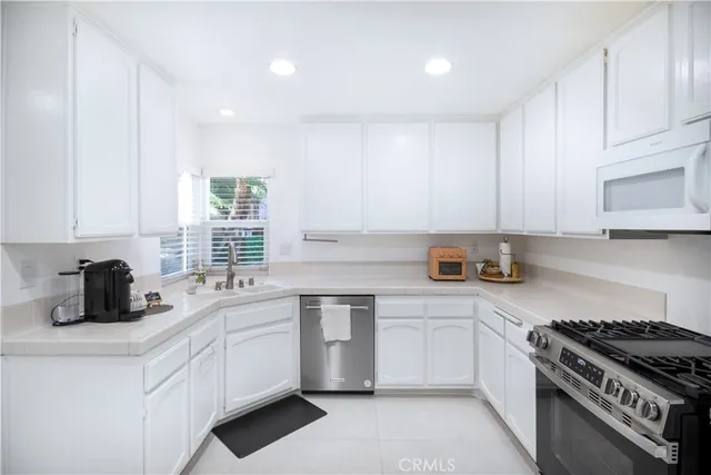 a kitchen with white cabinets and appliances