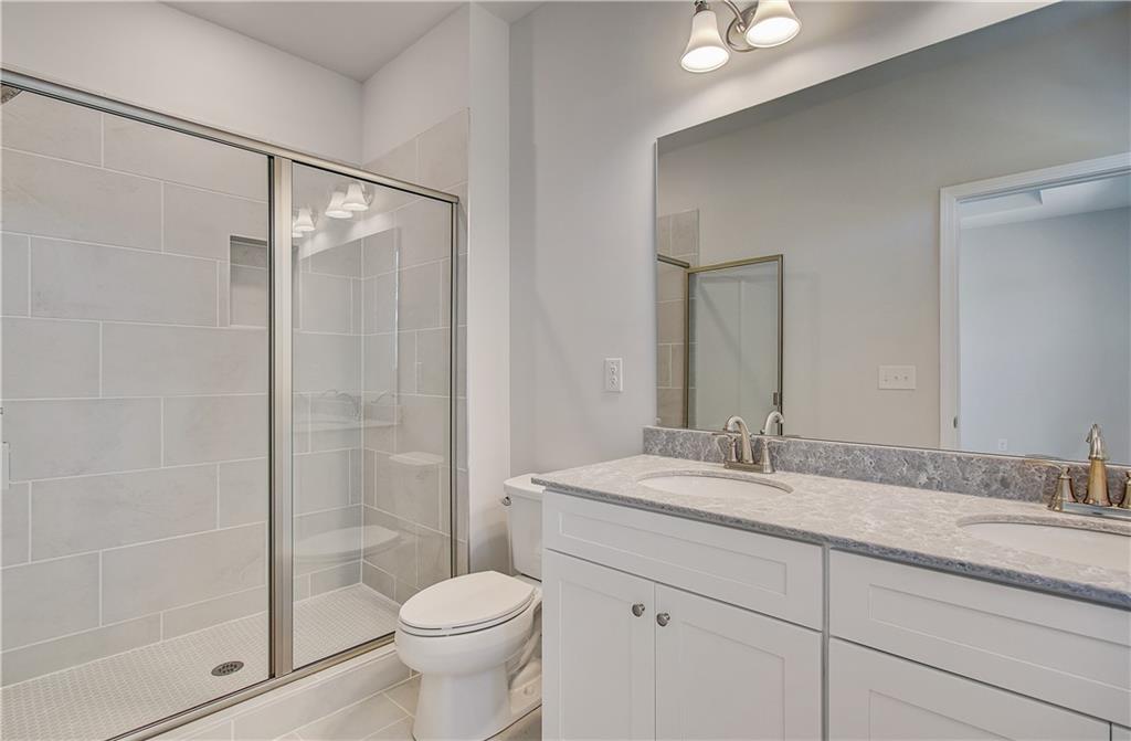 1903 Daybreak Lane Newnan, GA 30265 - Photo 26 of 29 a bathroom with a granite countertop sink toilet and shower