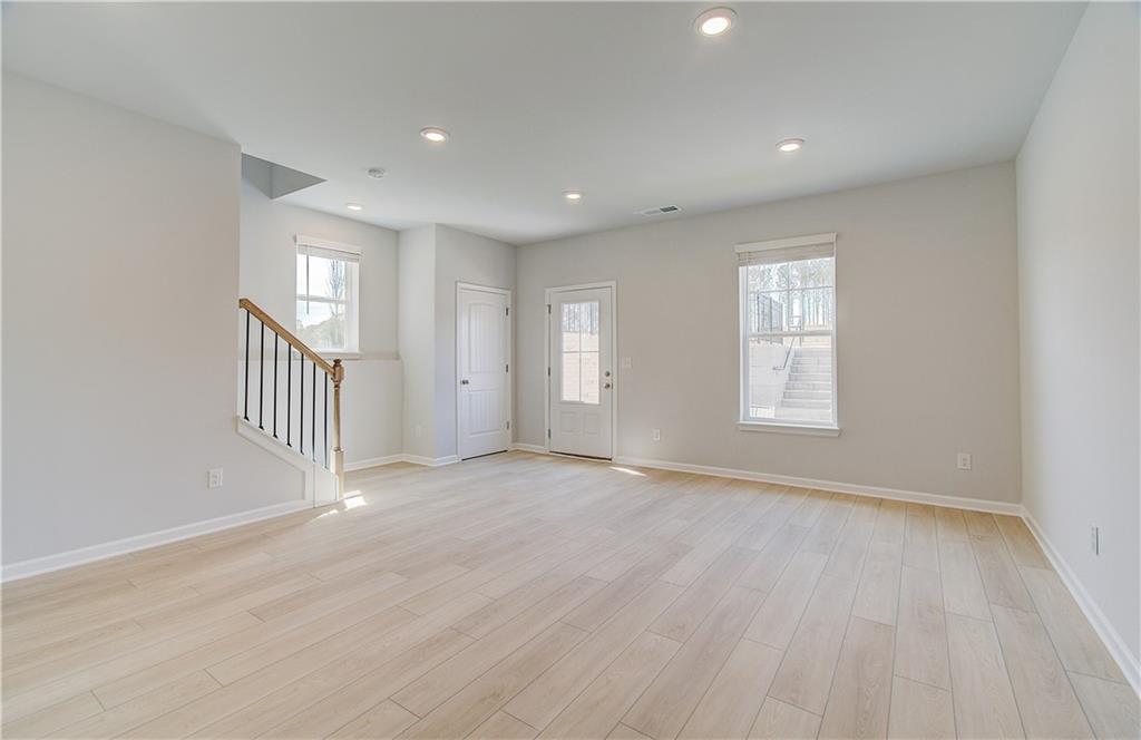 1903 Daybreak Lane Newnan, GA 30265 - Photo 6 of 29 an empty room with wooden floor and windows