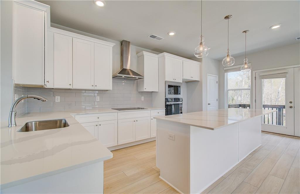 1903 Daybreak Lane Newnan, GA 30265 - Photo 7 of 29 a kitchen with kitchen island a counter top space appliances and cabinets