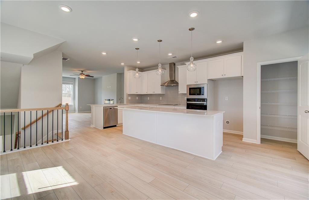 1903 Daybreak Lane Newnan, GA 30265 - Photo 10 of 29 a kitchen with stainless steel appliances kitchen island sink refrigerator and microwave
