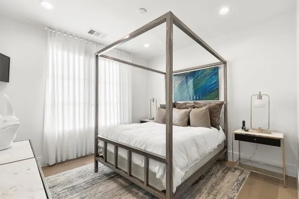 a bedroom with a bed a mirror and a window