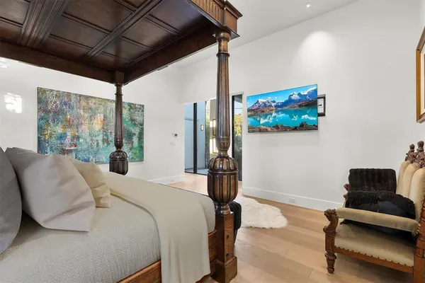 a bedroom with bed and wooden floors