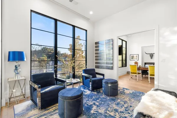 a living room with furniture a fireplace and large windows