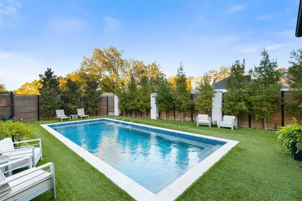 a view of a swimming pool with a yard and sitting area