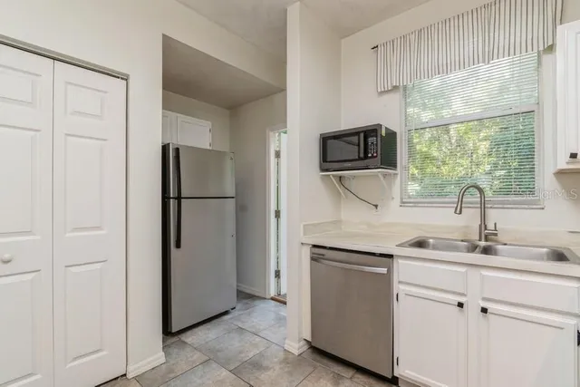 a kitchen with a refrigerator sink and cabinets