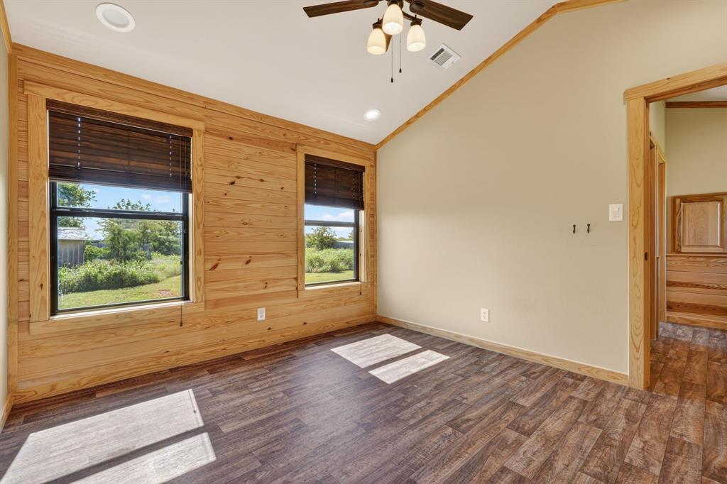 2401 Lamkin Road Mineral Wells, TX 76067 - Photo 18 of 36 an empty room with wooden floor fan and windows