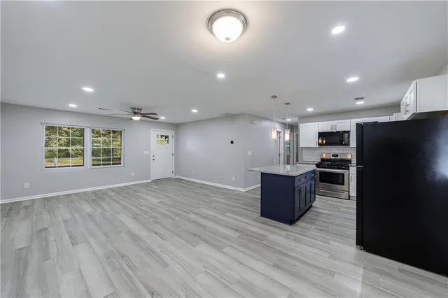 a kitchen with stainless steel appliances granite countertop wooden cabinets granite counter tops and a hard wood floors