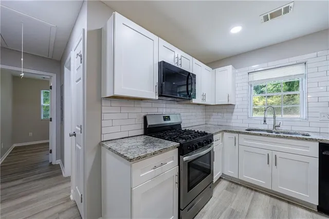 a kitchen with stainless steel appliances granite countertop a refrigerator and a sink