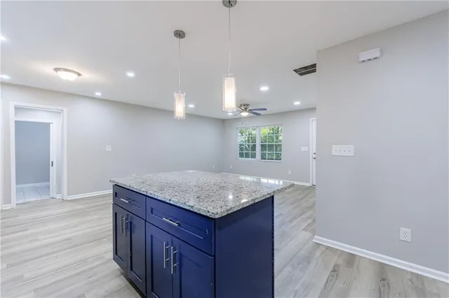 a kitchen with stainless steel appliances granite countertop a sink a stove and a wooden floors