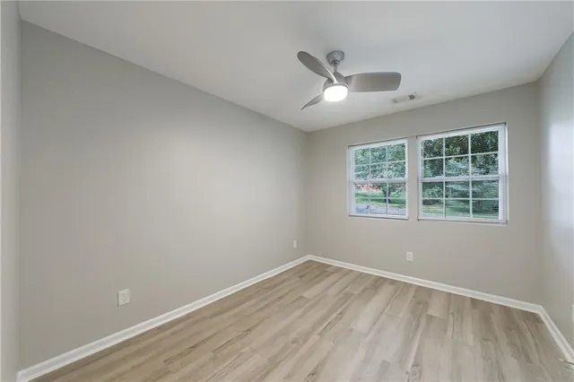 an empty room with a window and wooden floor