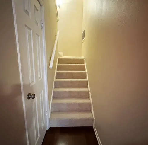 a view of staircase with white walls and white door
