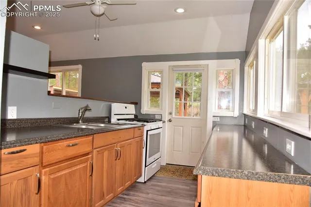 a kitchen with stainless steel appliances granite countertop a stove a sink and a granite counter tops with wooden floors
