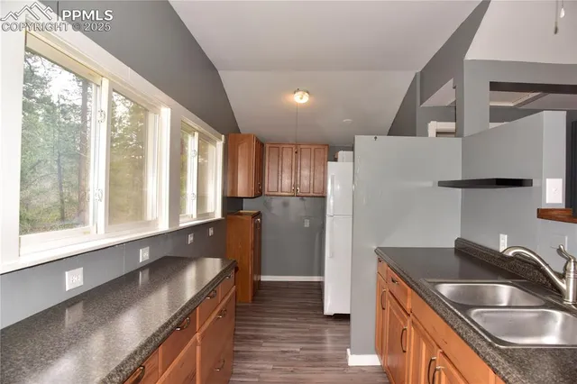 a kitchen with granite countertop a sink and a refrigerator