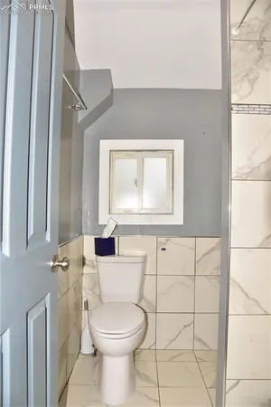 a bathroom with a toilet a sink and a mirror