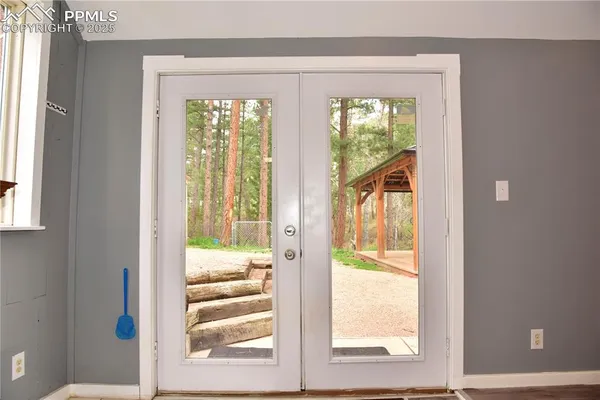 a view of a room that has a large window and front door