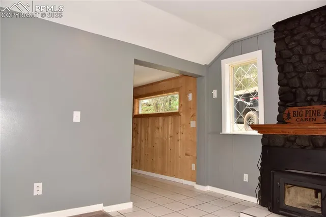 a view of an empty room with a fireplace and a window
