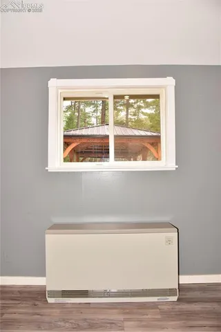 a view of a room that has a window and a wooden floor