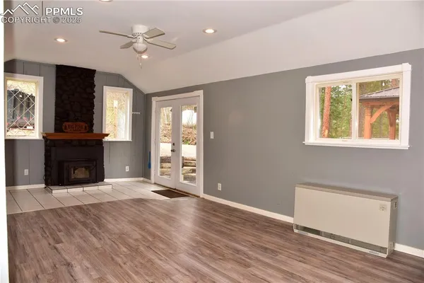 a view of an empty room with window and wooden floor