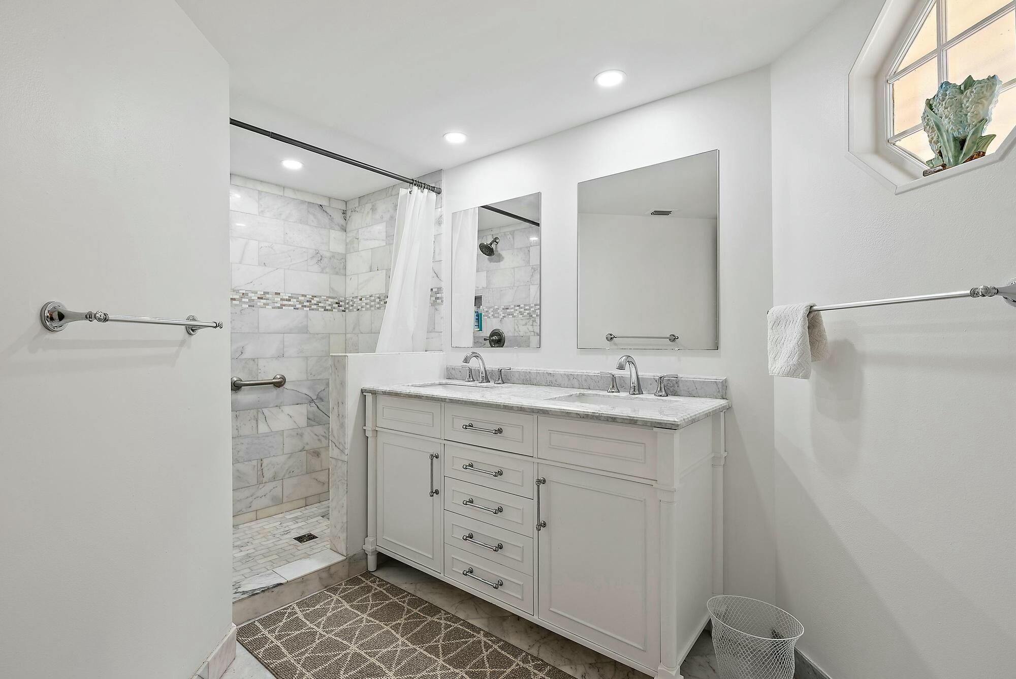 213 Seabreeze Circle Jupiter, FL 33477 - Photo 14 of 38 a bathroom with a shower sink and mirror