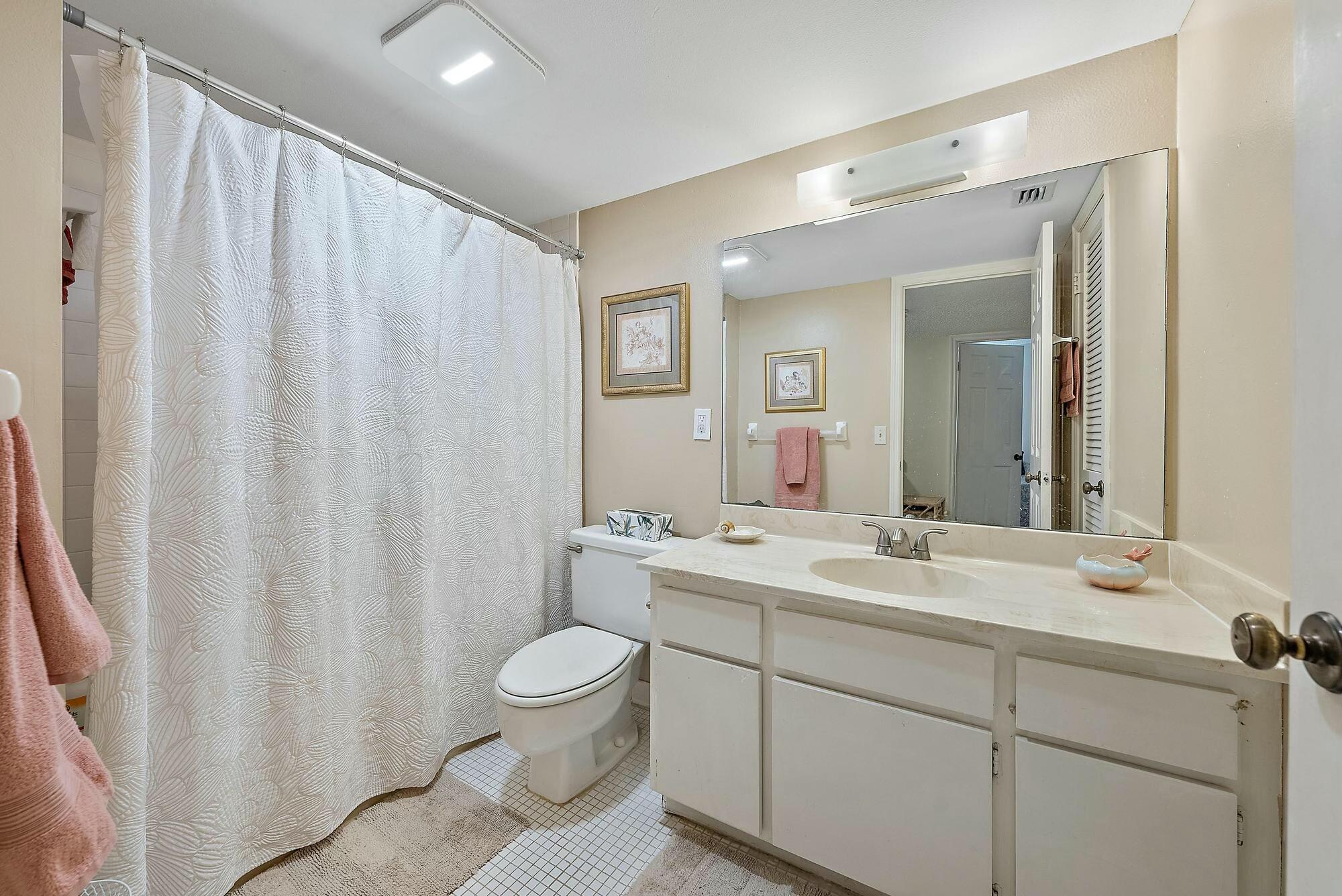 213 Seabreeze Circle Jupiter, FL 33477 - Photo 18 of 38 a bathroom with a double vanity sink toilet and a mirror