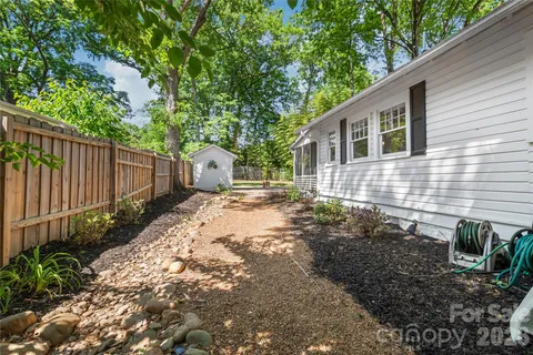a backyard of a house with plants and tree