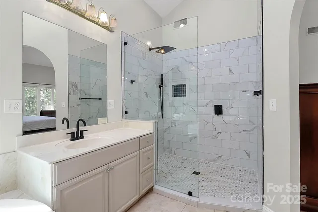a bathroom with a shower sink and mirror