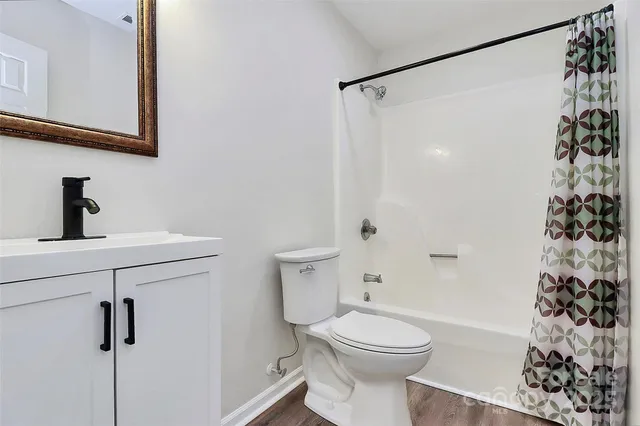 a bathroom with a sink a toilet and shower curtain