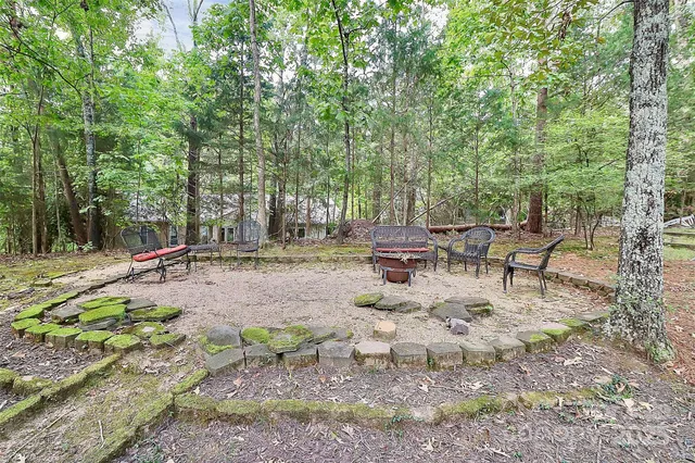 a view of a house with a yard tree and wooden fence