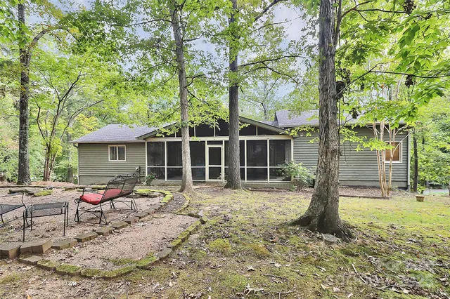 a view of a house with a yard and large tree