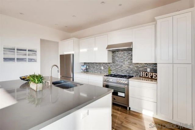 a kitchen with a sink a refrigerator and cabinets