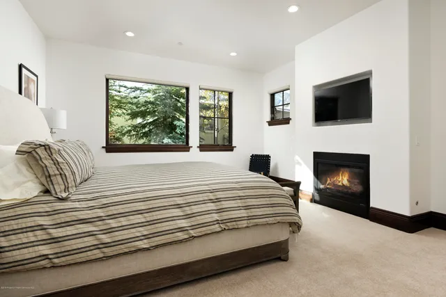 a spacious bedroom with a bed and a fireplace