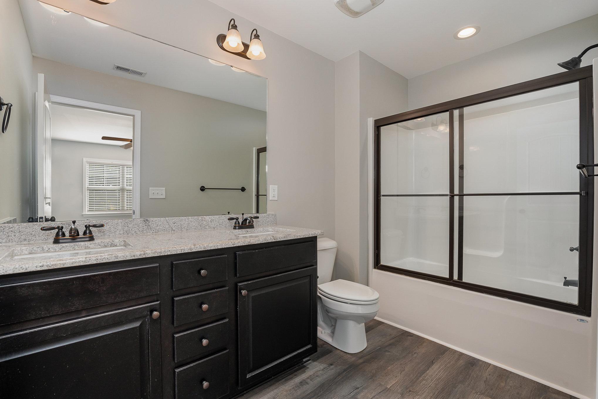 407 East 3rd Street Princeton, NC 27569 - Photo 10 of 18 a spacious bathroom with a double vanity sink toilet mirror and a shower