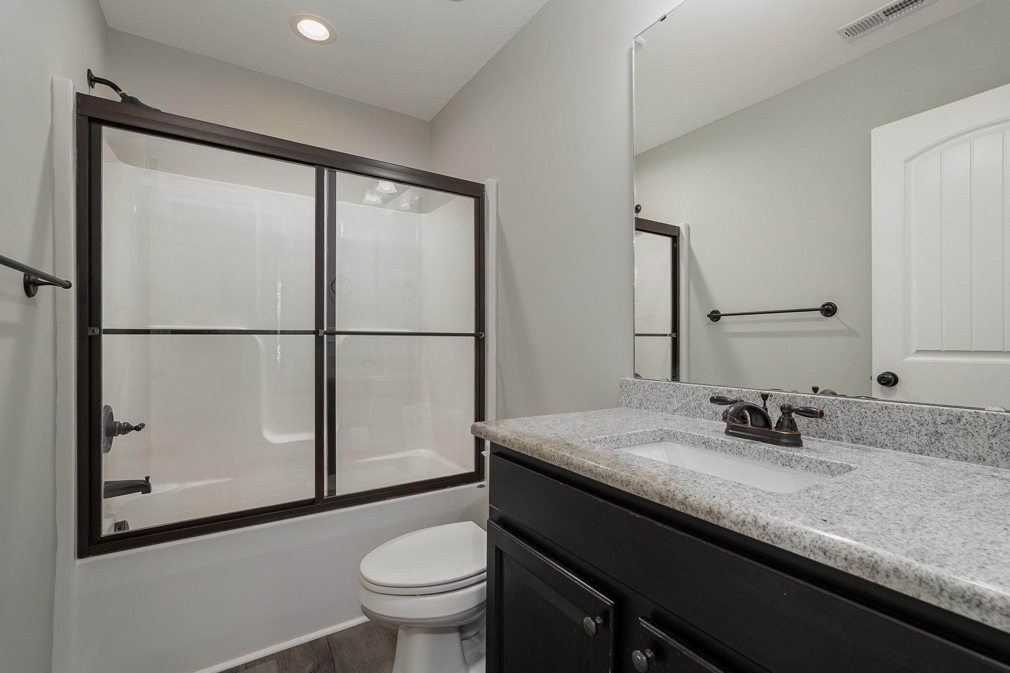 407 East 3rd Street Princeton, NC 27569 - Photo 14 of 18 a bathroom with a granite countertop sink toilet and mirror