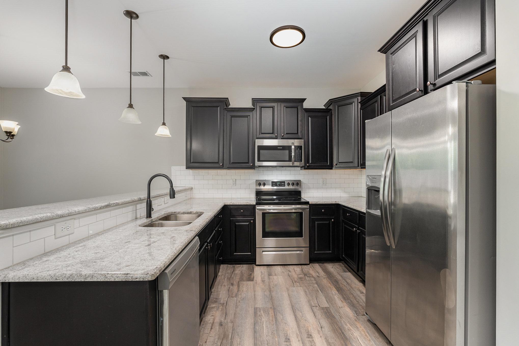 407 East 3rd Street Princeton, NC 27569 - Photo 4 of 18 a kitchen with stainless steel appliances granite countertop a sink a stove and refrigerator