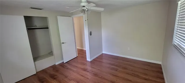 an empty room with wooden floor and a window