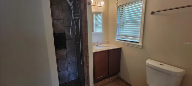 a bathroom with a toilet a sink and a window
