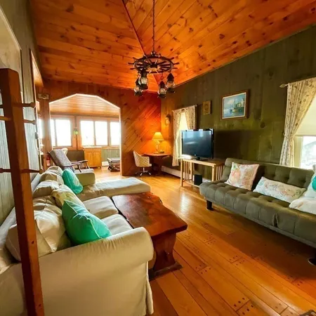 a living room with furniture a flat screen tv and a large window