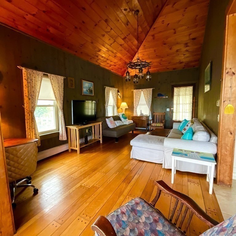 230 Manomet Point Road Plymouth, MA 02360 - Photo 6 of 15 a living room with furniture a flat screen tv and a large window