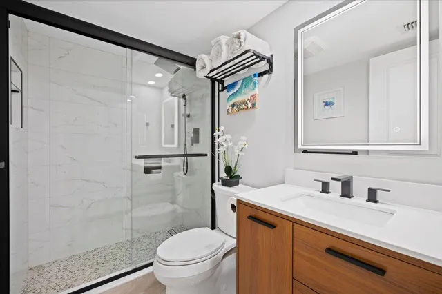 a bathroom with a sink a toilet and shower