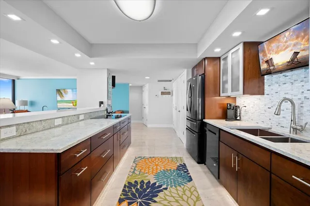 a large kitchen with stainless steel appliances granite countertop a lot of counter space and a sink