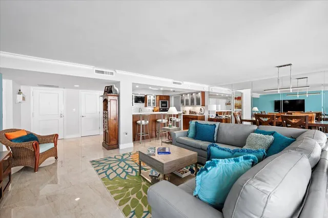 a living room with furniture and a view of kitchen
