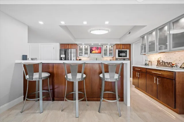 a kitchen with stainless steel appliances granite countertop a table and chairs in it